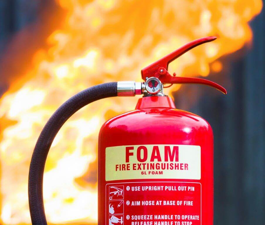 foam fire extinguisher in front of flames